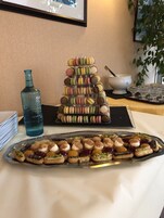Una bandeja escalonada con macarons y una charola de pasteles variados.