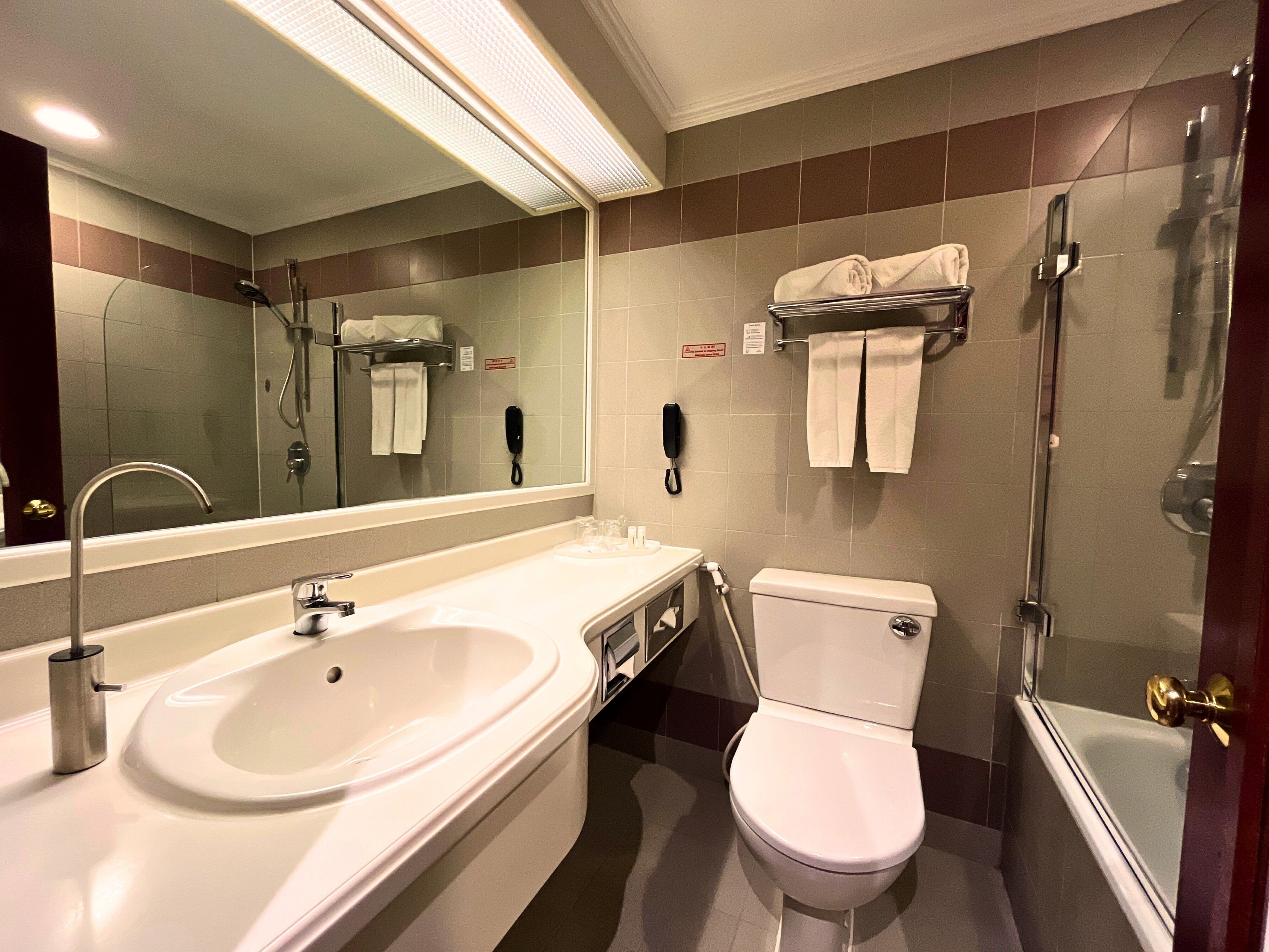 A modern bathroom with a large sink, toilet, and shower.