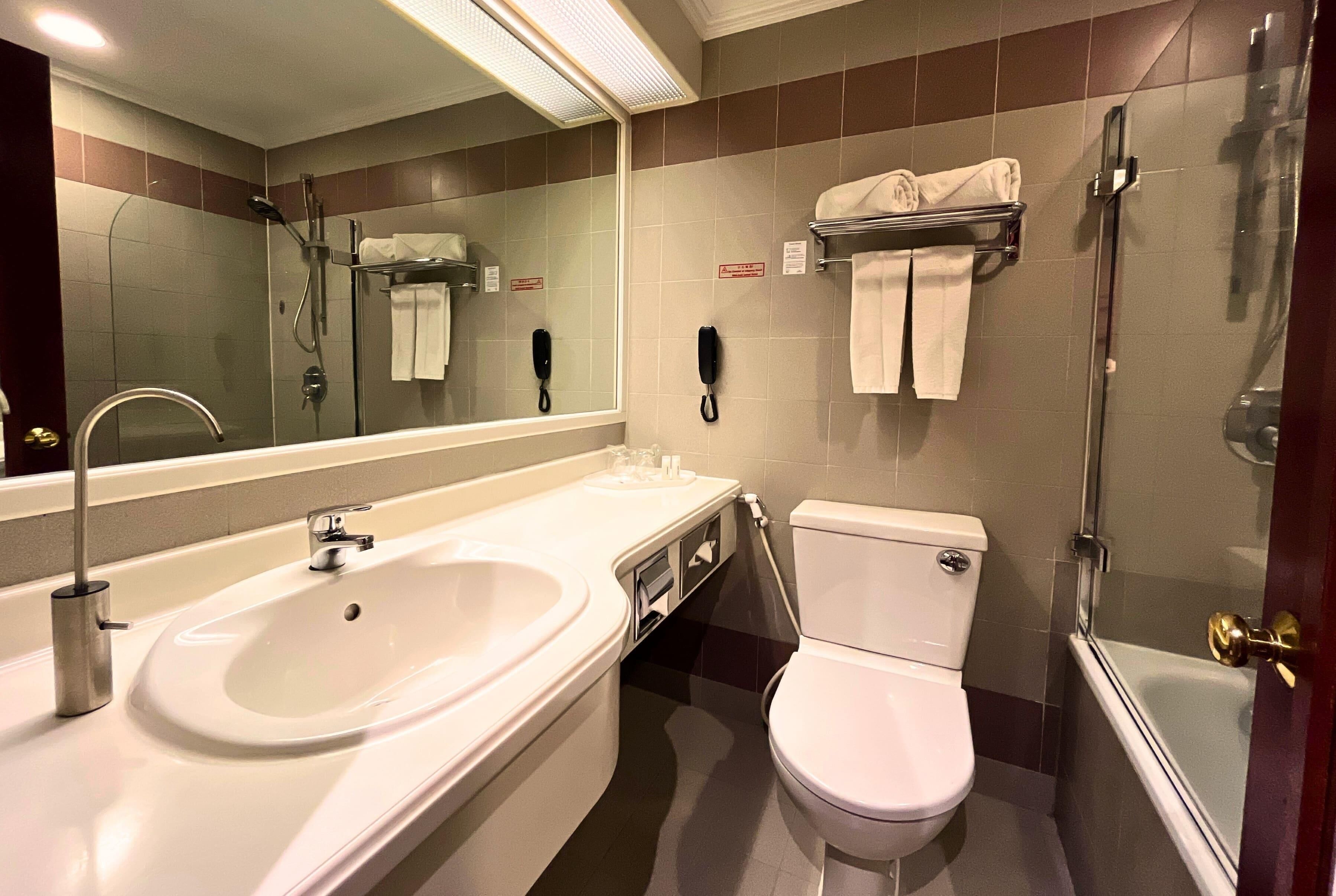 A bathroom with a sink, toilet, and shower.