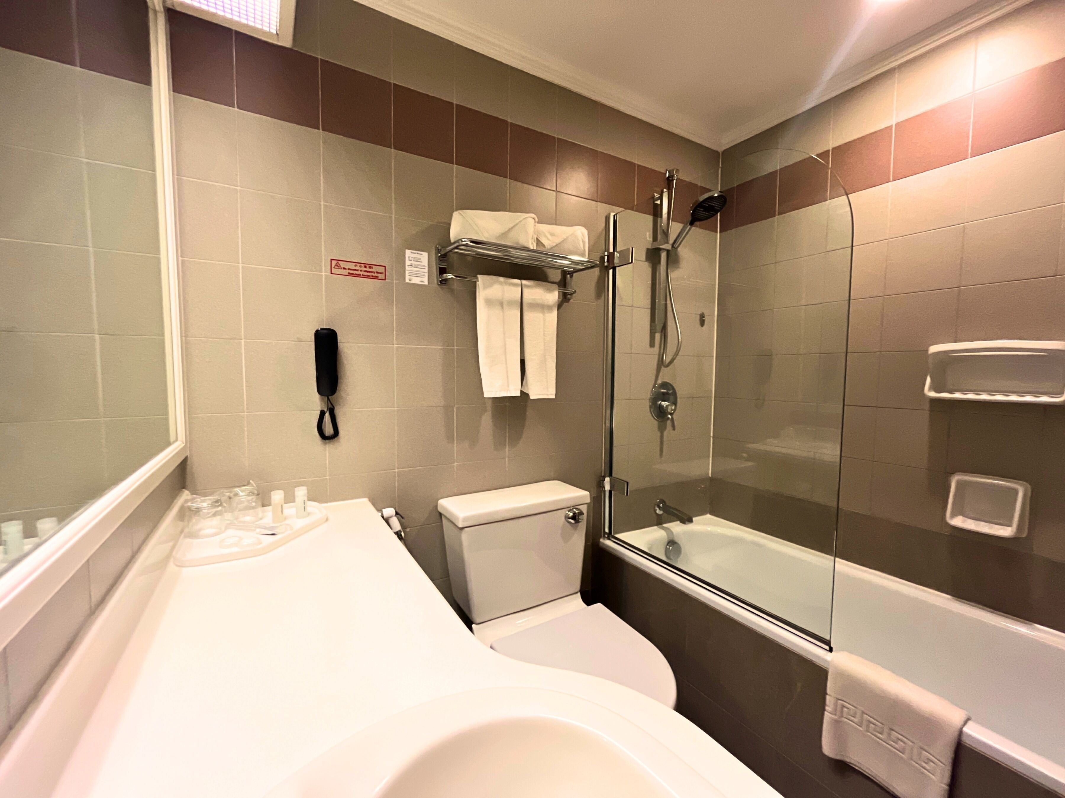 A modern bathroom with a glass-enclosed shower, a white toilet, and a bathtub.