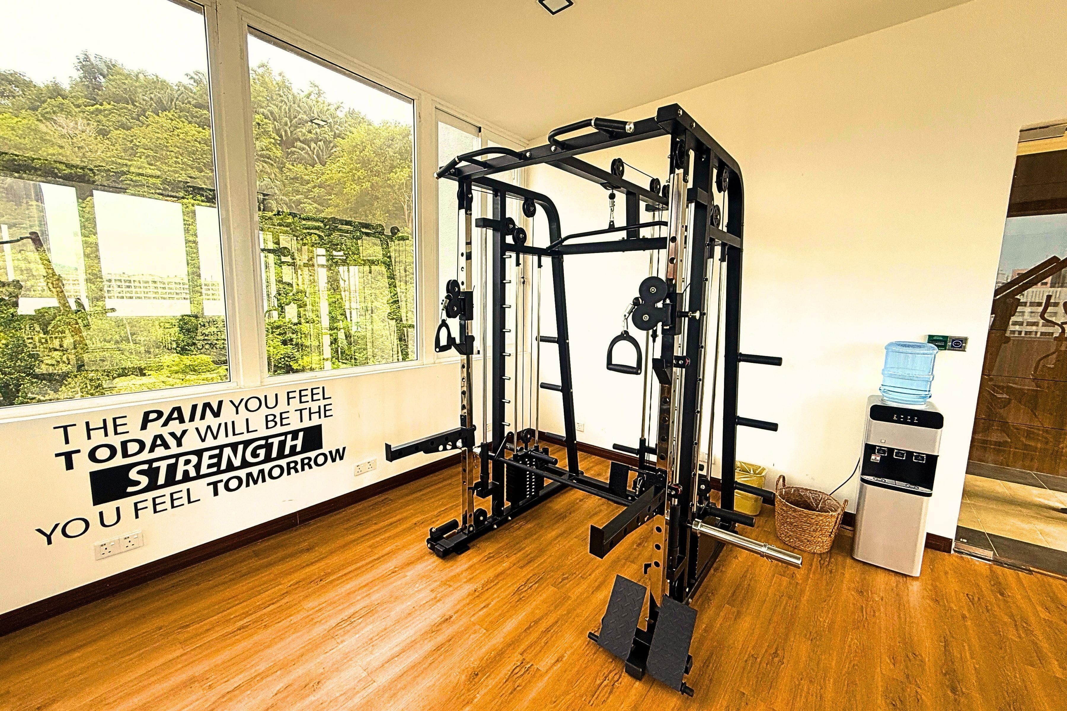 A gym with a pull-up bar, weight machine, and a motivational quote on the wall.
