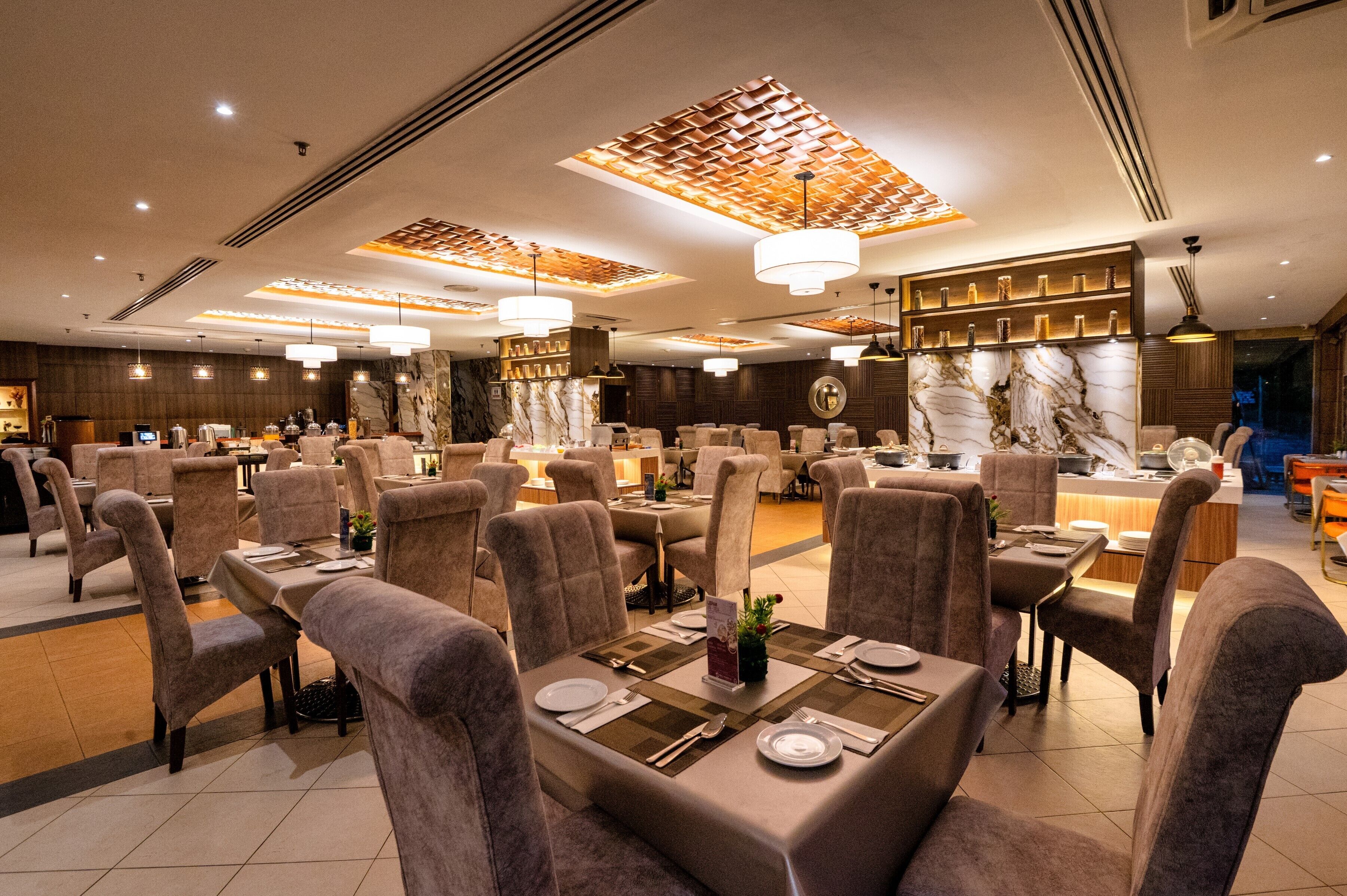 A spacious restaurant with multiple dining areas, each featuring tables set with plates, cutlery, and napkins.