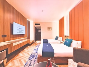 A hotel room with two beds, a television on the wall, and a wooden floor. - Howard Johnson by Wyndham Kota Kinabalu City Centre (Kota Kinabalu)