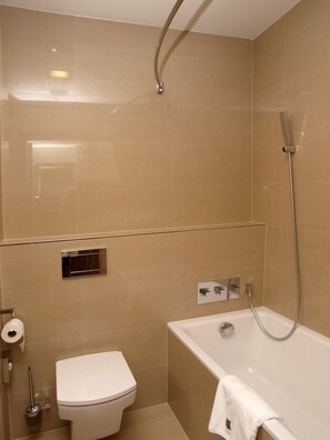 A bathroom with a toilet, a bathtub, and a shower. - Hotel Budweis (Ceske Budejovice)