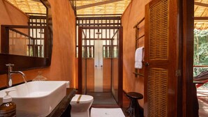 Un baño con una bañera grande, un inodoro y un lavamanos con espejo.