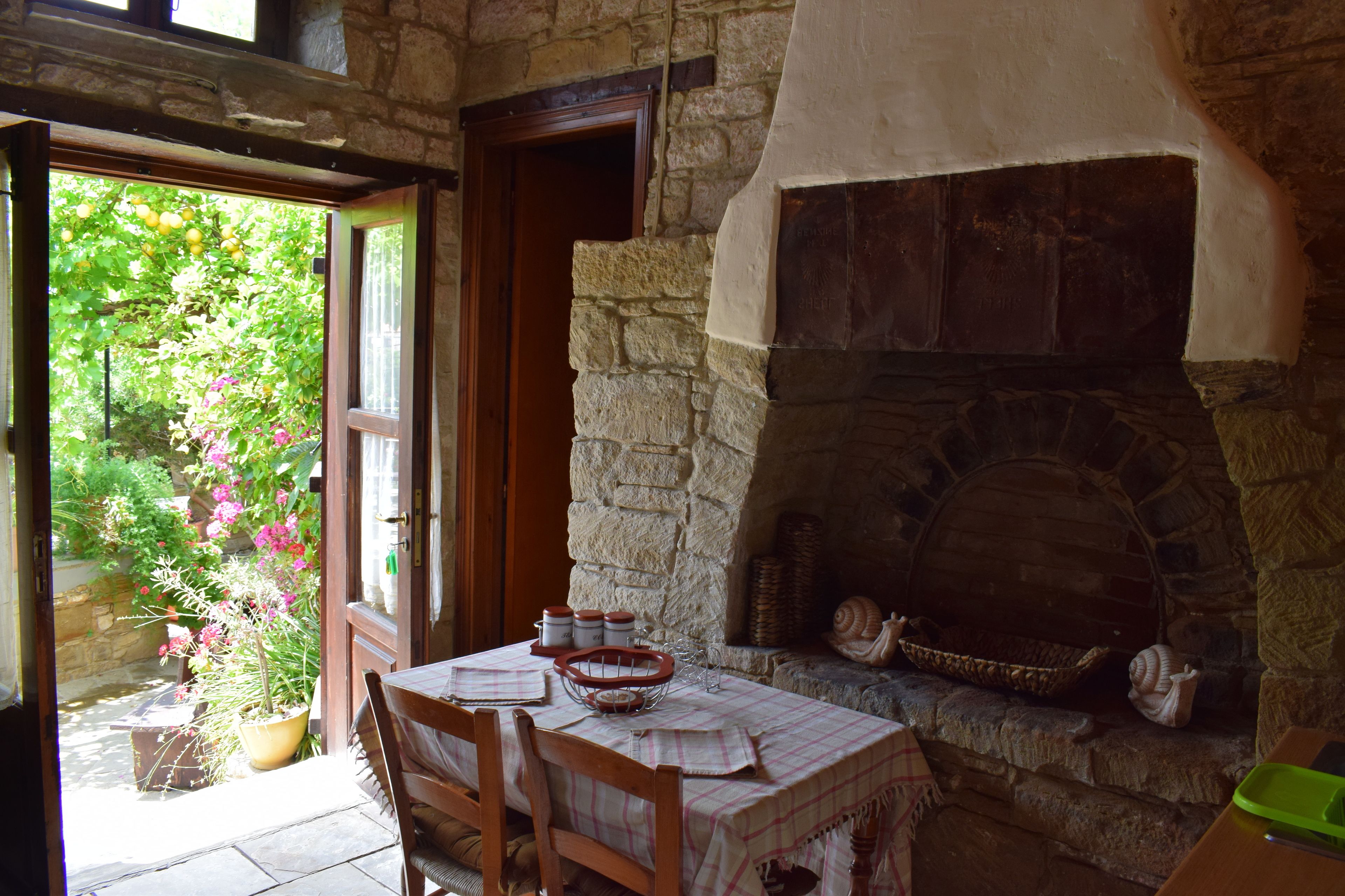 A stone fireplace with a basket and a snail shell on the hearth.