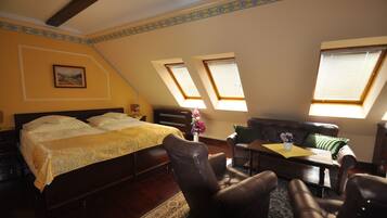Un dormitorio con cama, escritorio y dos ventanas.