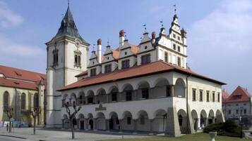 Um edifício histórico com uma torre imponente e janelas em arco.
