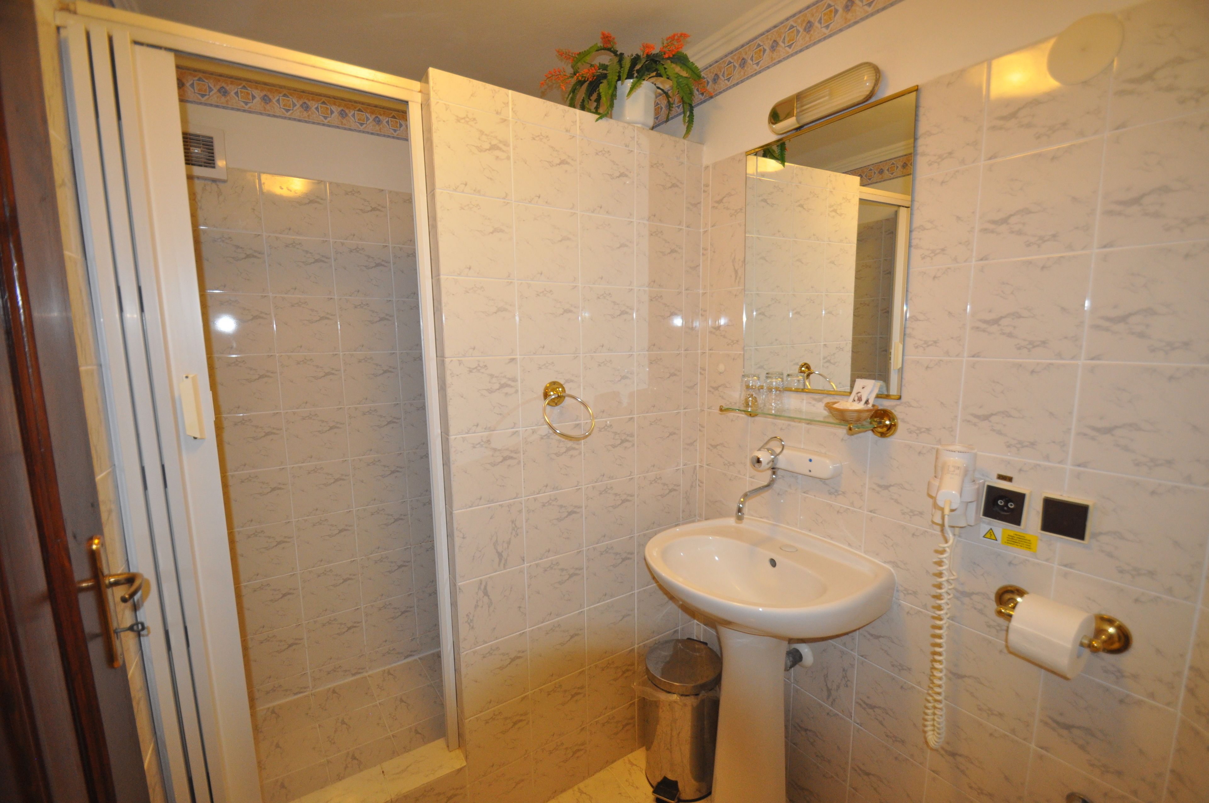 Un baño con ducha, lavamanos e inodoro.