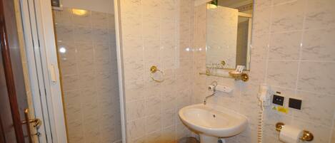 Un baño con ducha, lavamanos e inodoro.