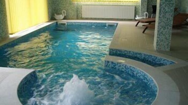 A spa area with a hot tub and a smaller circular hot tub. - Hotel Mirni Kutak (Otocac)