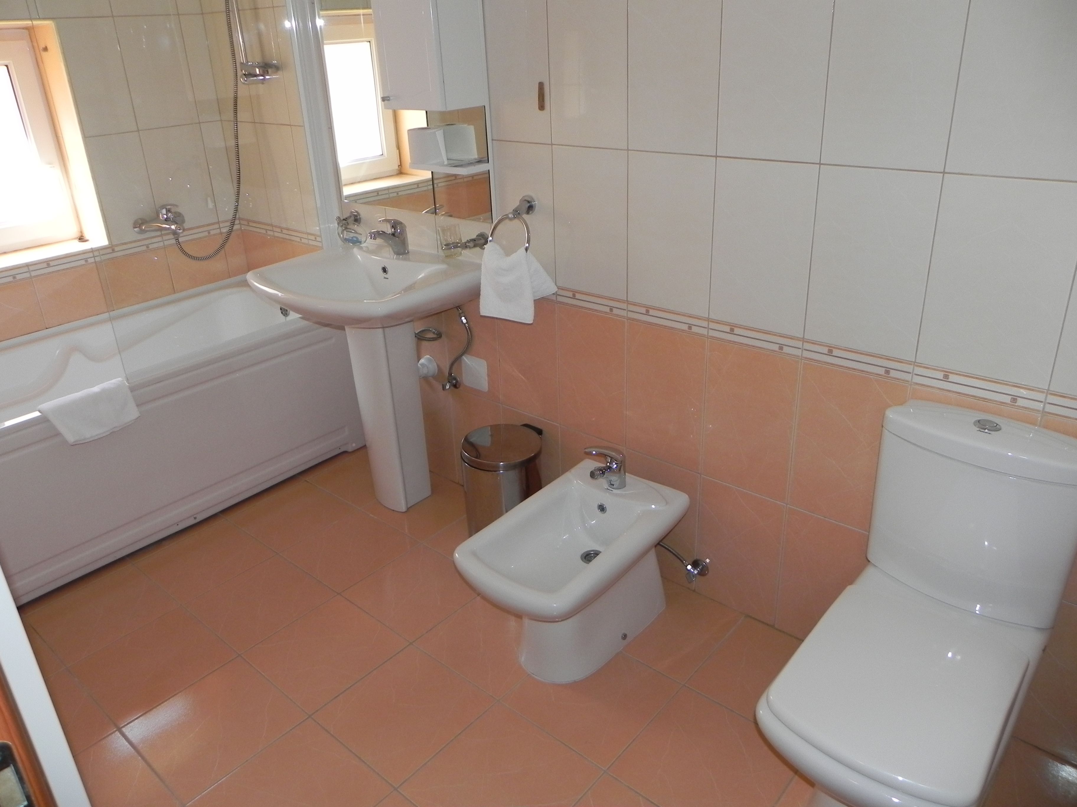 A bathroom with a bathtub, a sink, a bidet, and a toilet.