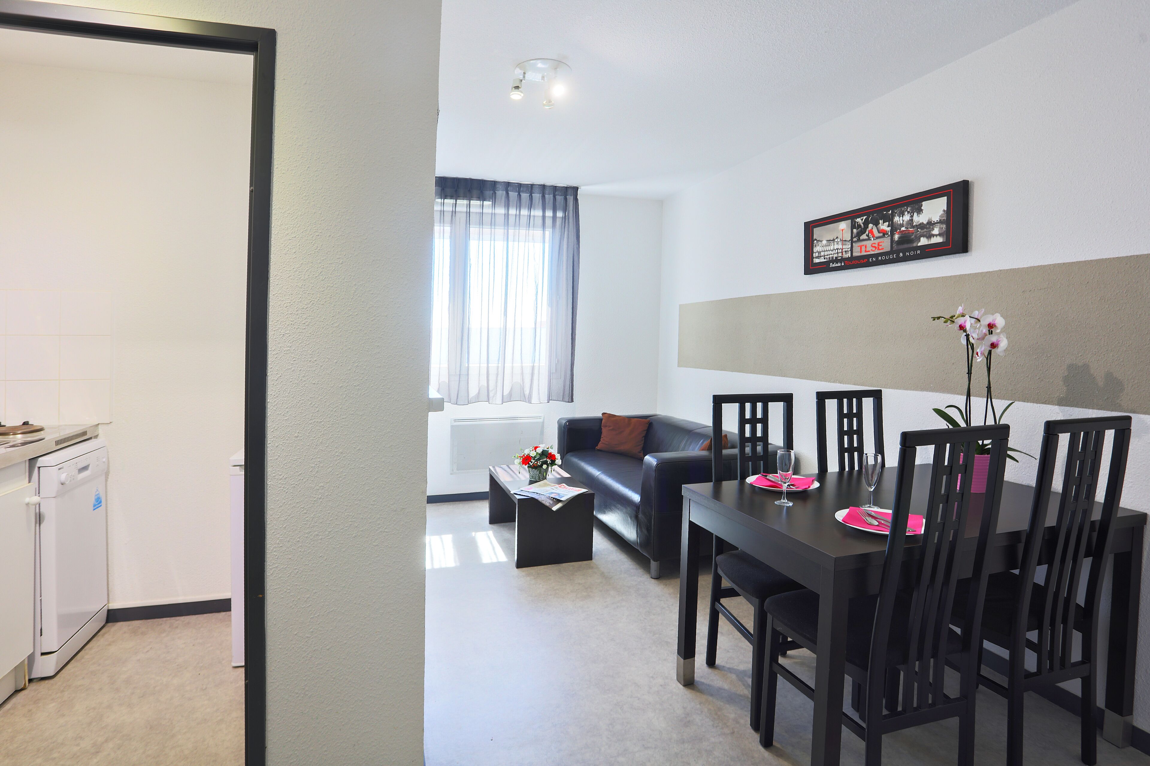 Un salon moderne comprenant un coin repas, un canapé, une table basse et une table à manger avec des chaises.