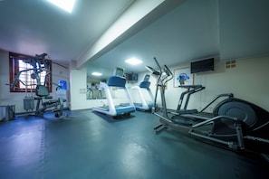 A gym with treadmills, elliptical machines, and weightlifting equipment.
