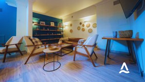 Una sala de estar moderna con sofá, sillones, una mesa de centro y una estantería.