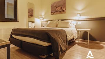 A bedroom with a bed, bedside table, and wall art.