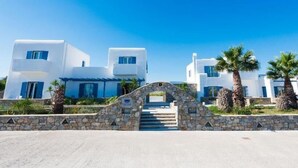 A white building with a stone archway leading to a staircase.