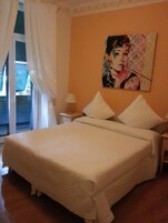 Una camera da letto con un letto, un comodino, una lampada e un quadro appeso al muro.
