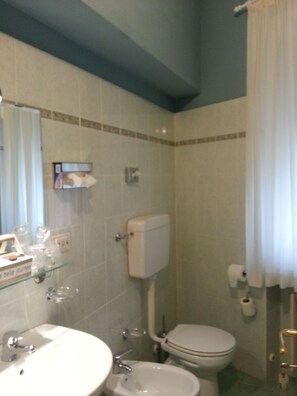 Ein Badezimmer mit Waschbecken, Toilette und Duschvorhang.