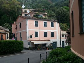 Un edificio rosa con un cartello per l'Hotel Argentina, un bar di spuntini e vino, e un segnale che indica divieto di parcheggio.