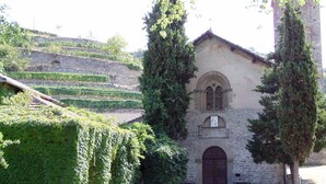 A stone building with a large arched entrance and a bell tower.