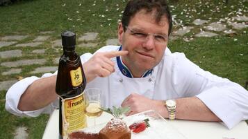 Iemand zit aan een tafel met een biertje, een glas en een toetje.