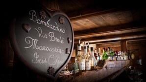 A chalkboard menu listing Bombardino, Vin Brule, Marocco, and Irish Coffee. - Genzianella (Valfurva)