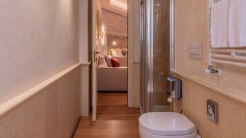 A narrow hallway leading to a bathroom with a shower, toilet, and sink.
