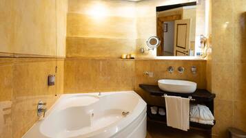 A modern bathroom with a large bathtub, a sink, and a vanity with a towel rack.