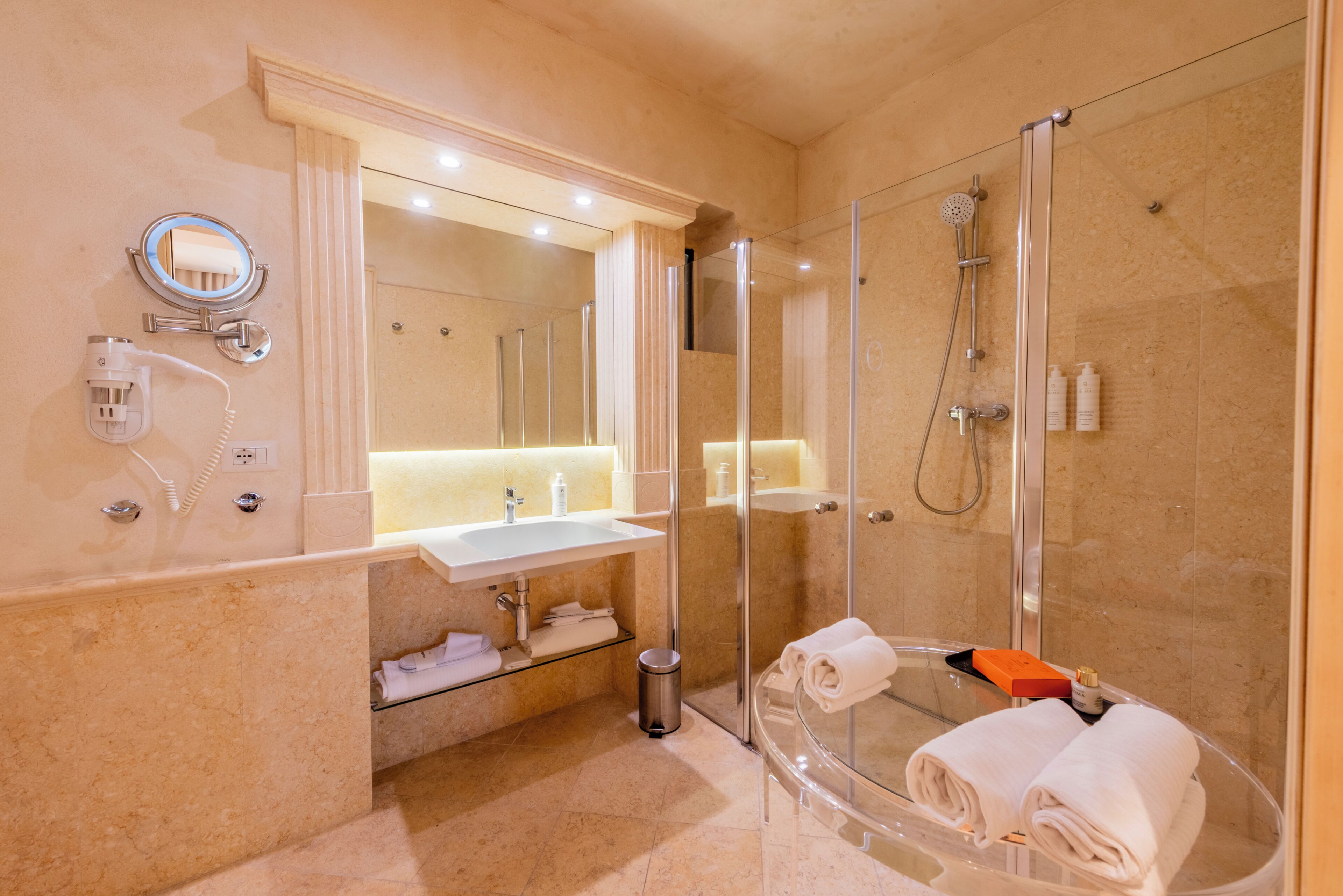 A modern bathroom with a glass-enclosed shower, a vanity with a mirror, and a sink.