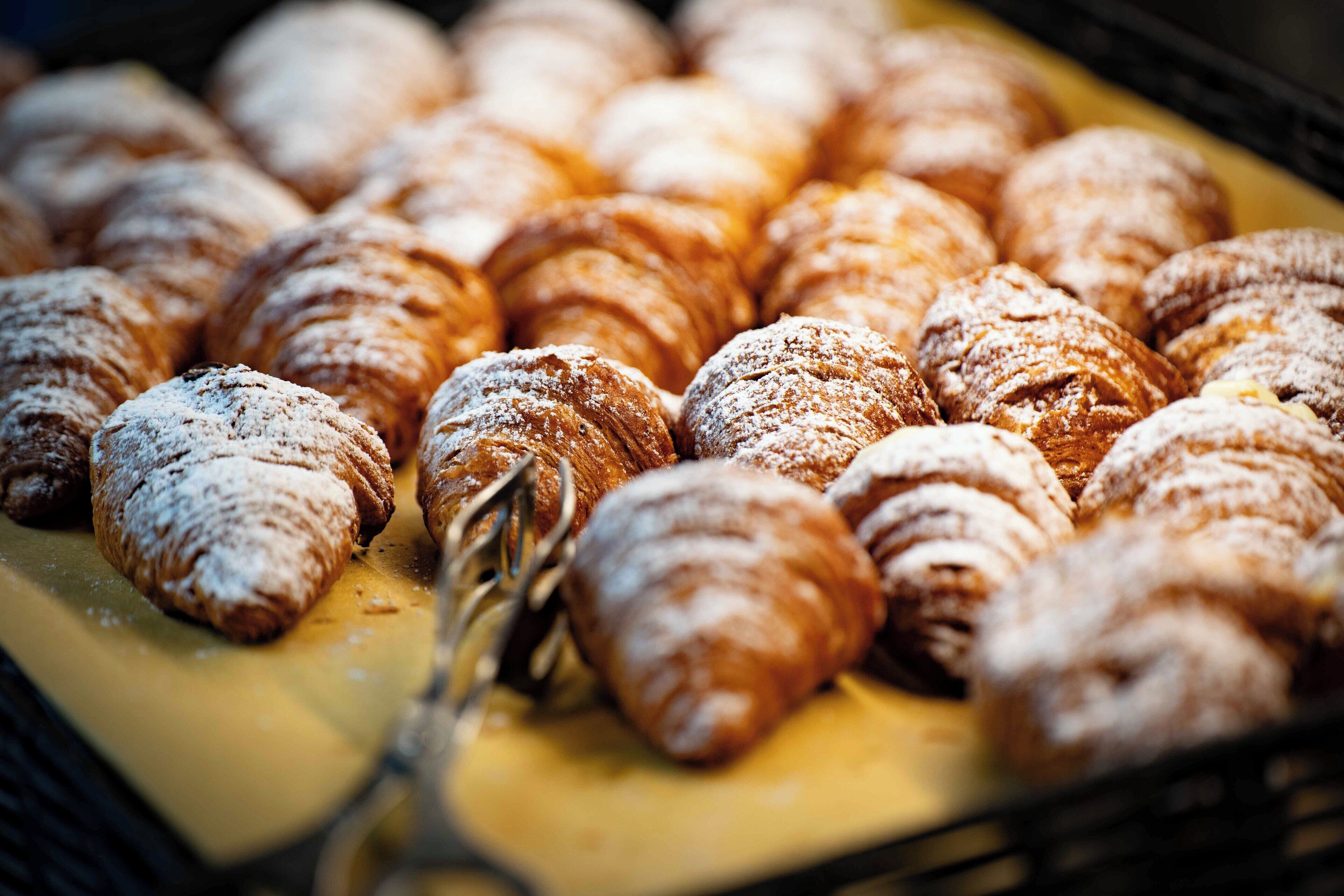 A tray of pastries dusted with powdered sugar.