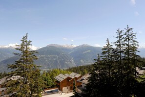 A mountain lodge with a view of snow-capped peaks. - Aparthotel Helvetia Intergolf (Crans-Montana)