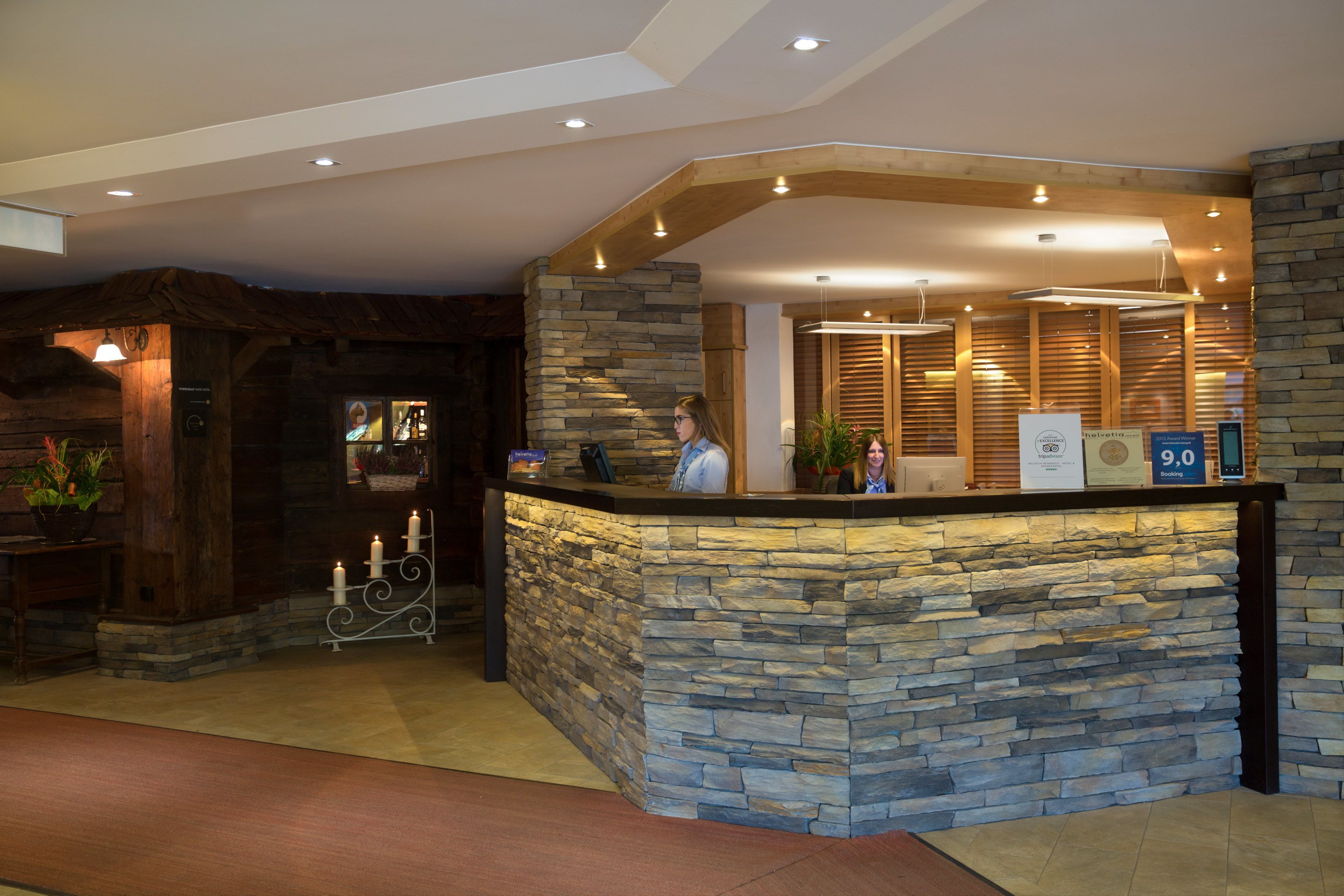 A reception area with a stone counter, wooden accents, and a modern ceiling design.