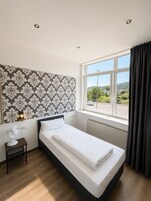 Escritorio, cortinas blackout y tabla de planchar con plancha