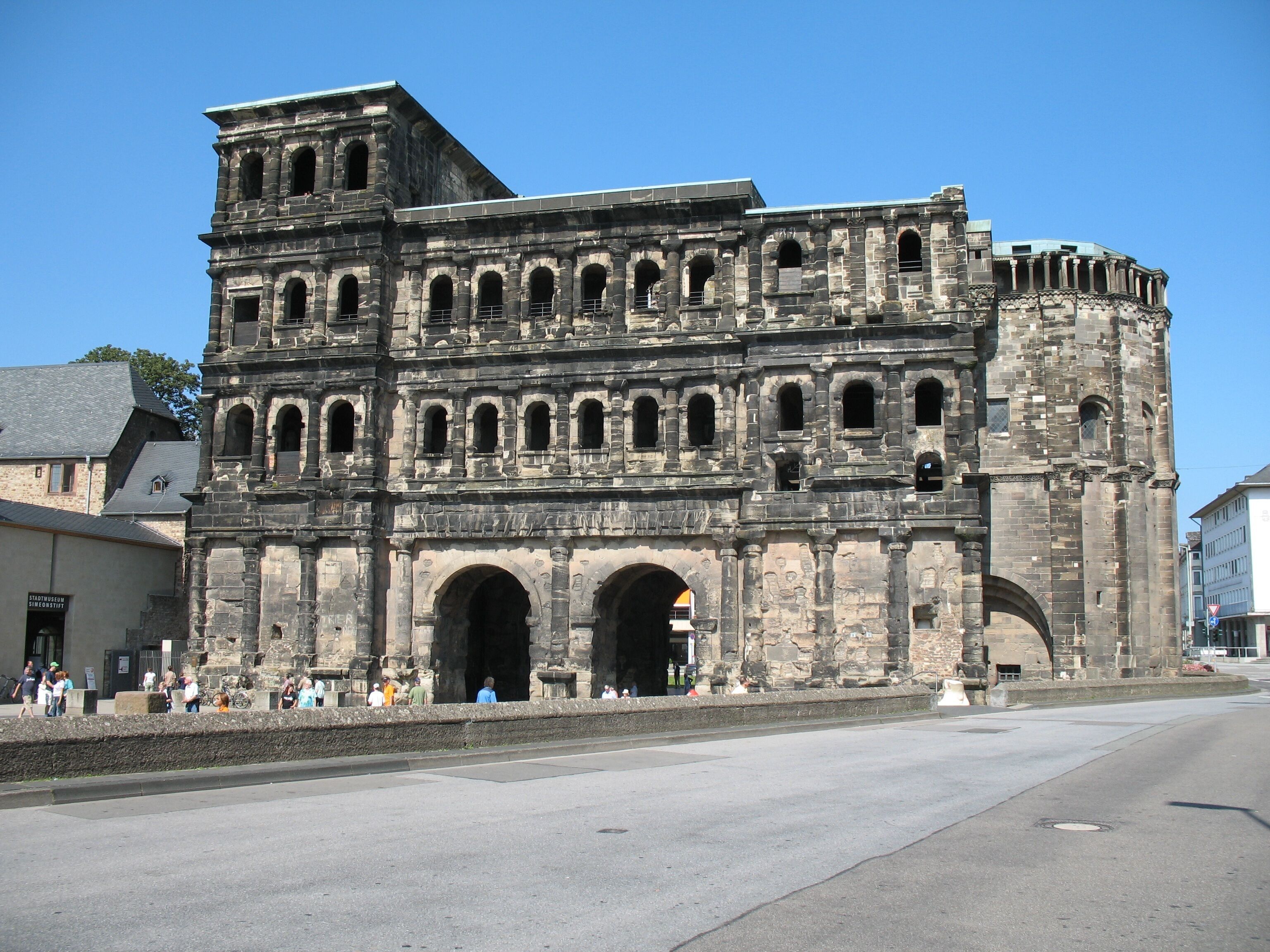 Un edificio histórico de piedra con múltiples arcos y una torre.