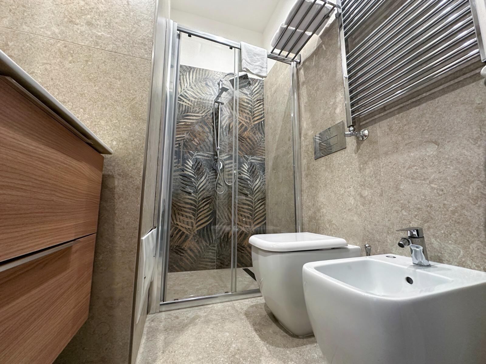 A modern bathroom with a glass shower enclosure, a toilet, and a sink.