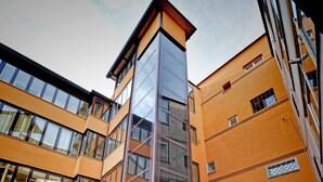 A multi-story building with large windows and a modern architectural design. - Hotel Barbato (Naples)