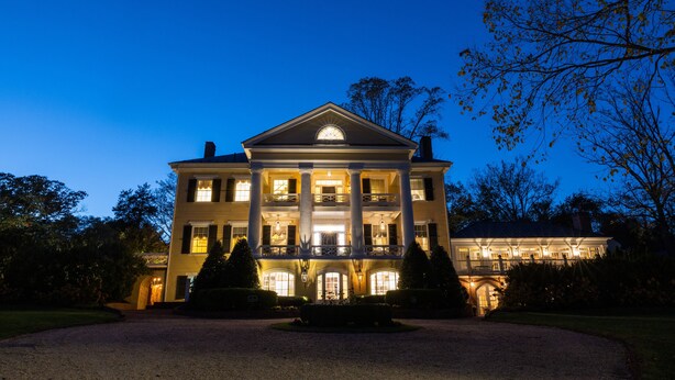 A large, two-story building with a symmetrical facade, multiple windows, and a central entrance. - Inn at Willow Grove (Orange)
