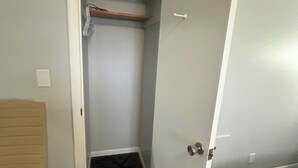Une pièce avec un placard, un lit et un tapis à motifs.