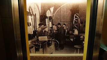 Une photographie ancienne représentant une pièce avec des plafonds en arc de cercle et une échelle, sur laquelle on peut voir une enseigne avec du texte.