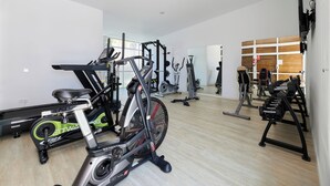 A gym with various exercise equipment including treadmills, stationary bikes, and weight machines. - Alua Boccaccio (Alcúdia)