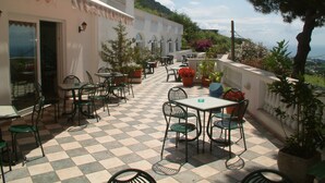 Un patio al aire libre con suelo de cuadros, mesas y sillas.
