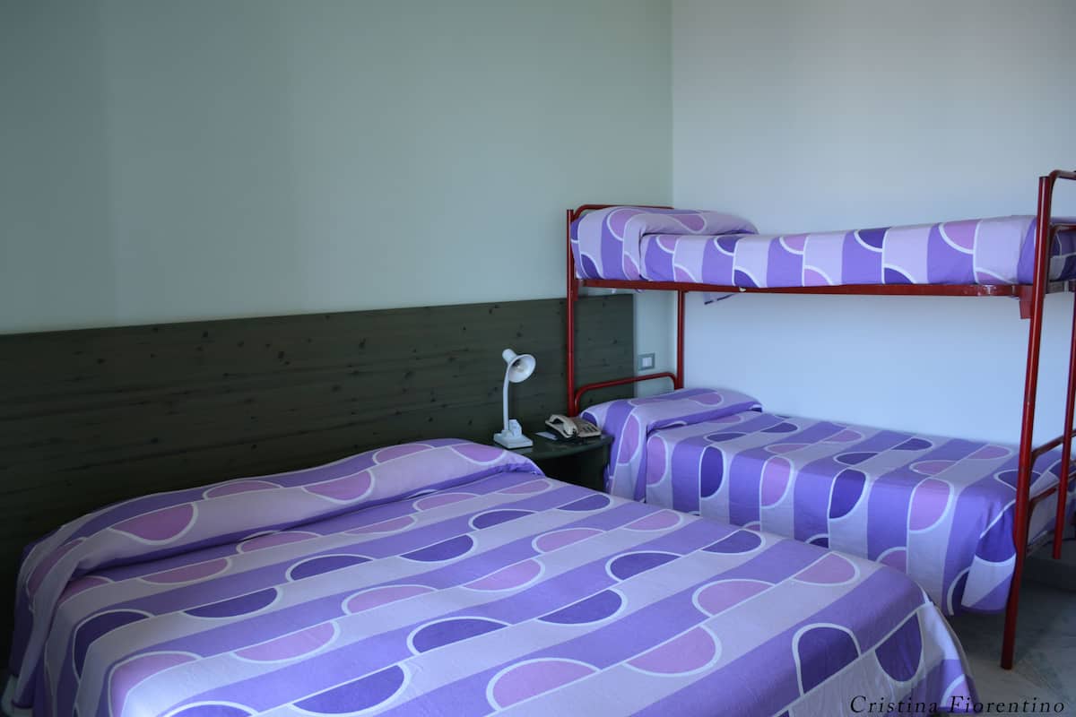 Ein Zimmer mit zwei Etagenbetten, jeweils mit einem gemusterten Bettbezug.
