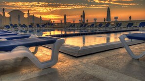 A poolside area with lounge chairs and a sunset view. - IL Mercato Splash Aqua Park (Sharm El Sheikh)