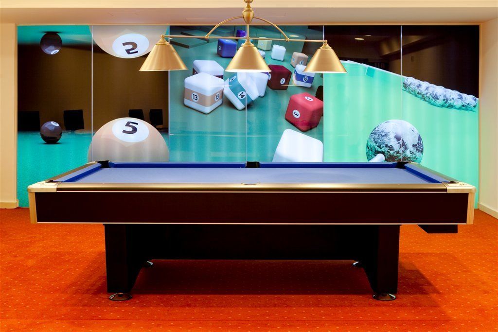 A pool table with three lamps, numbered balls, and a globe in the background.