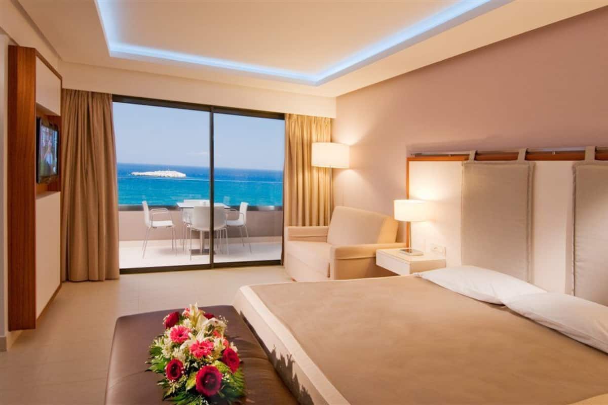 Una habitación de hotel con una cama grande, un escritorio, una silla y vistas al océano.