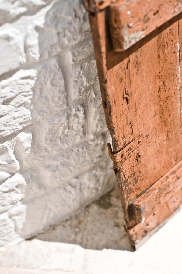 A close-up of a stone wall with a wooden door. - Le Alcove Luxury Resort nei Trulli (Alberobello)