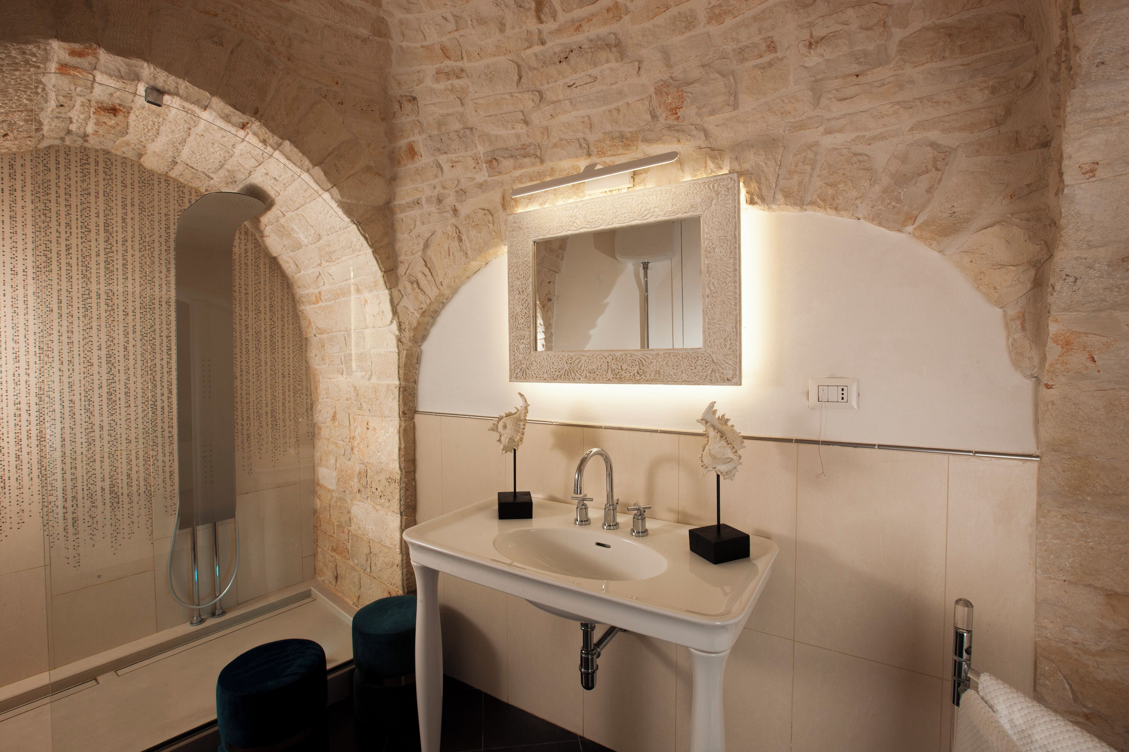 A bathroom with a white sink, a mirror, and a shower.