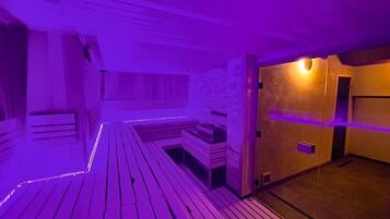Un sauna con bancos de madera y una pared de piedra.