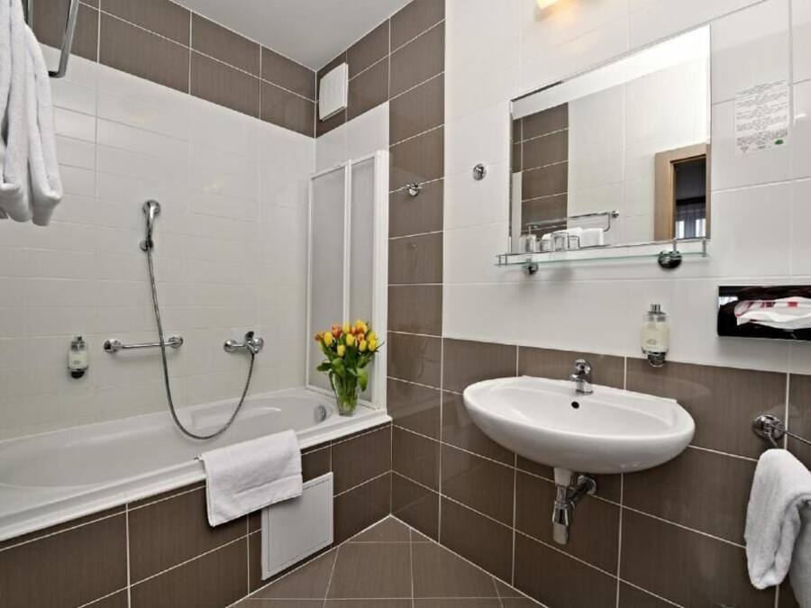 A modern bathroom with a bathtub, shower, and sink.